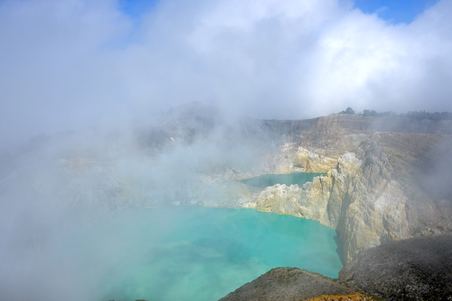 Nubi celano parzialmente la vista sui laghi incantati del Kelimutu.