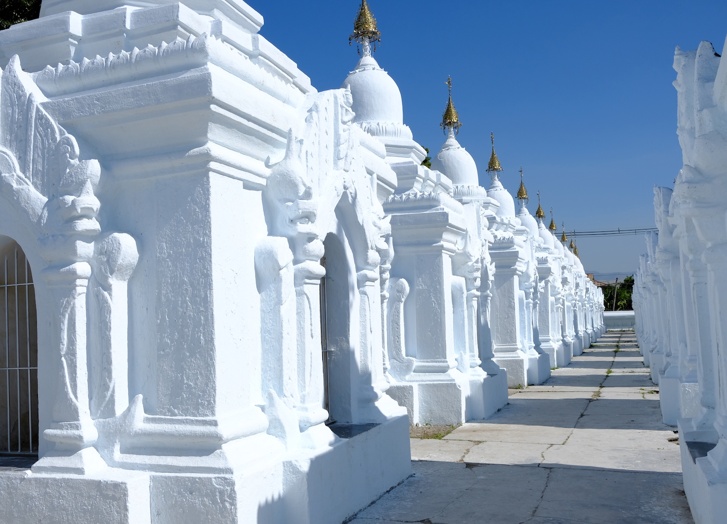 Piccoli stupa di color bianco che contengono le steli del canone Pali.