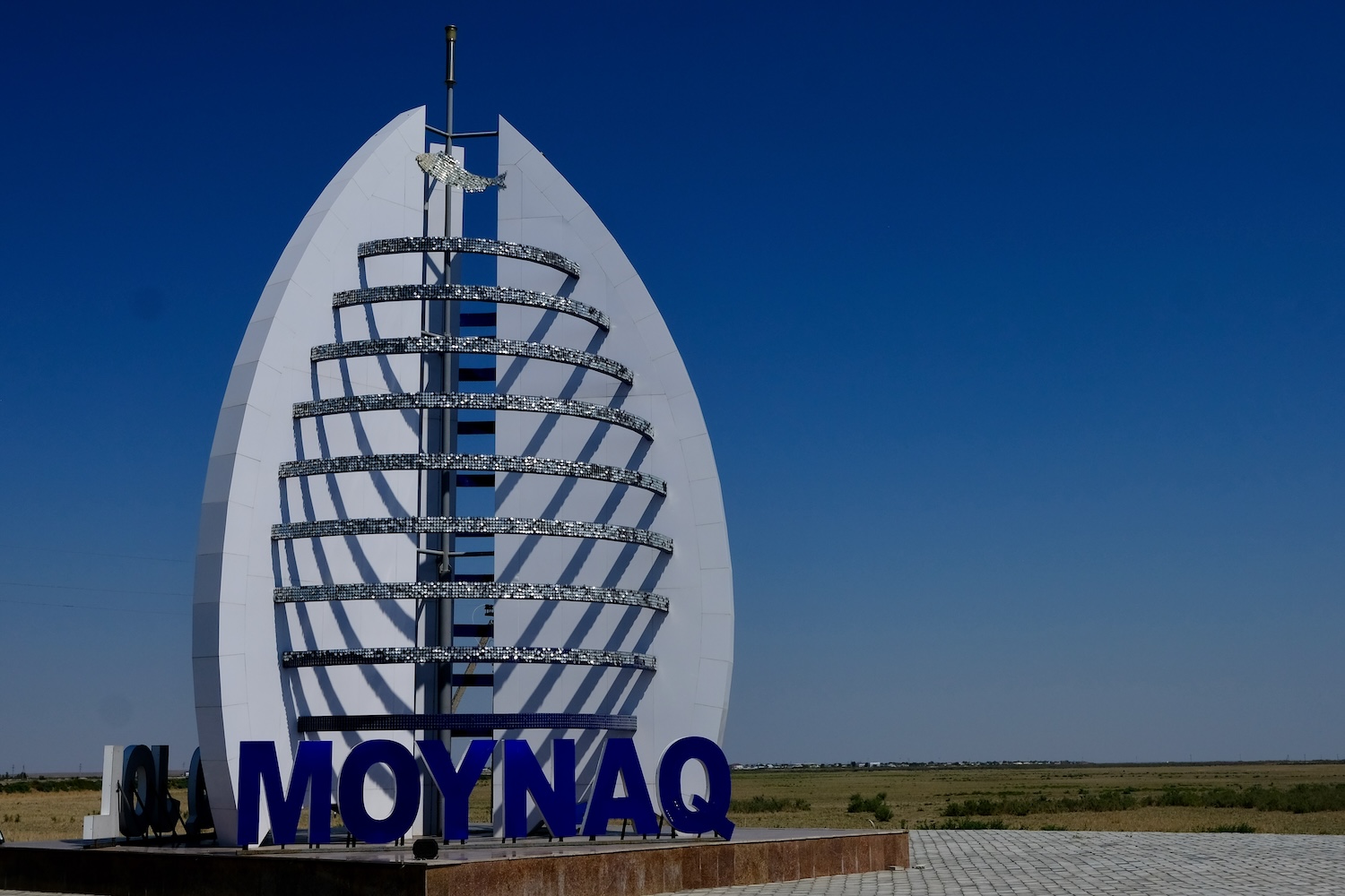 Monumento all'ingresso di Moynaq. Notate il pesce argentato issato in cima?